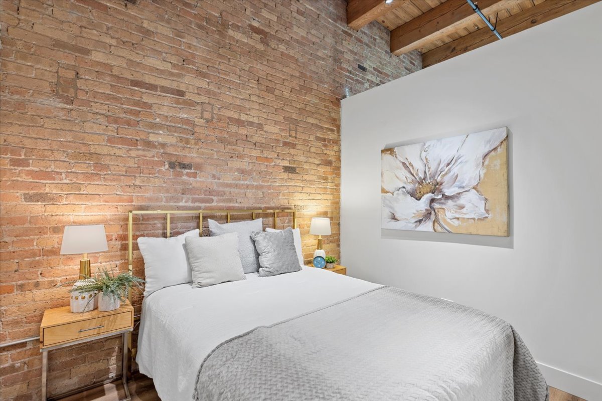 153 West Ohio Street, Unit 403 Chicago, IL 60654 - Photo 8 of 15 a bedroom with a bed and wall painting