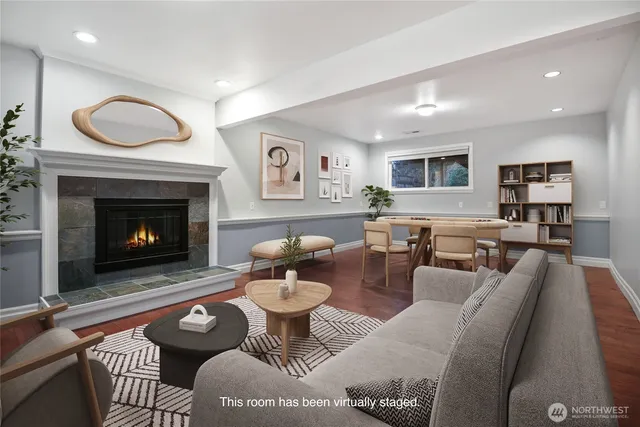 a living room with furniture a fireplace a rug and kitchen view