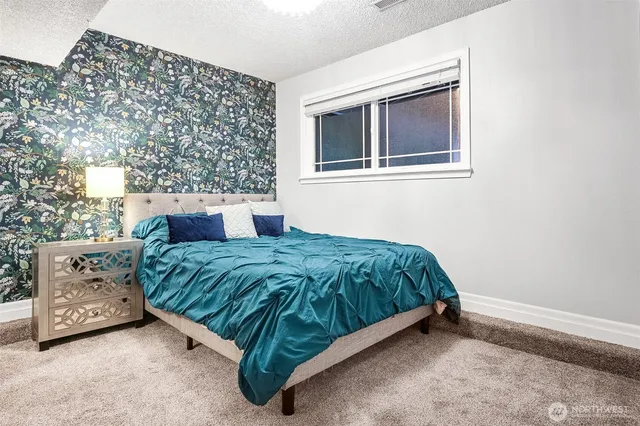 a bed sitting in a bedroom next to a window