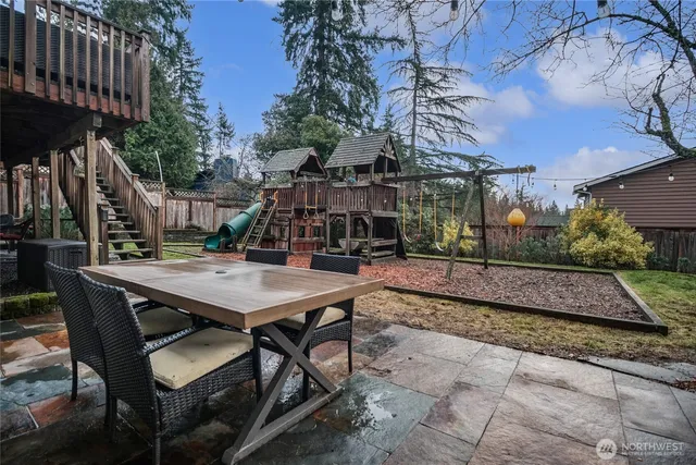 a view of a patio with table and chairs with wooden floor and fence