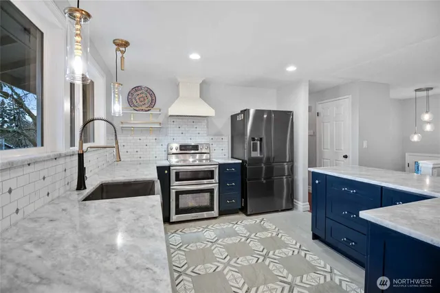 a kitchen with stainless steel appliances a stove a sink and a refrigerator
