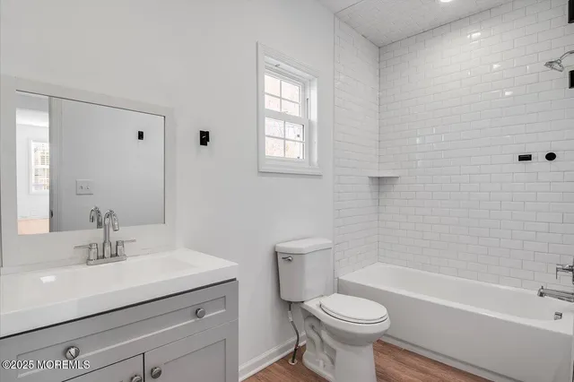 a bathroom with a sink a toilet a mirror and shower