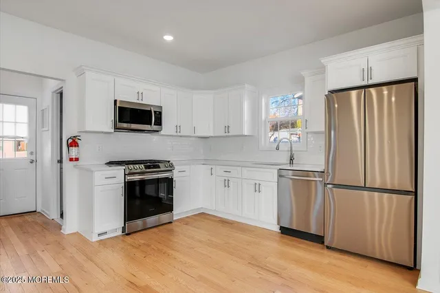 a kitchen with granite countertop a refrigerator stove and sink