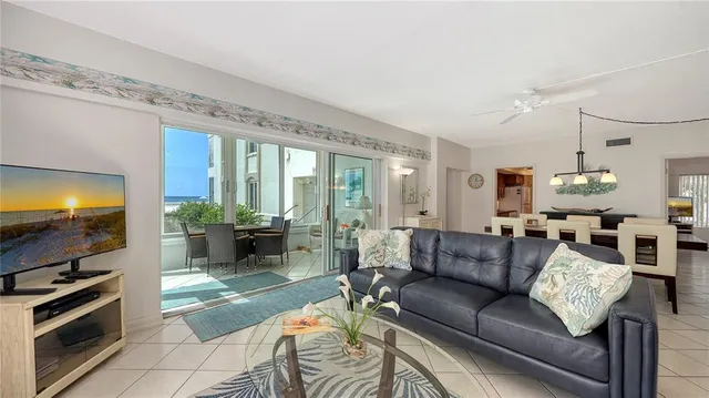a living room with furniture flat screen tv and a large window