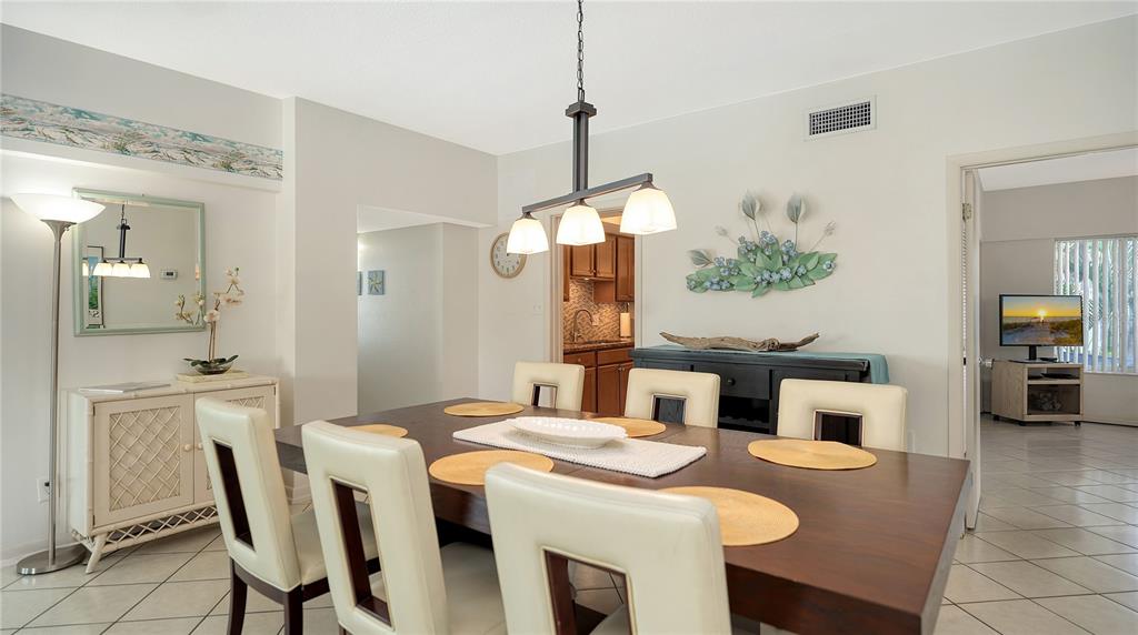6144 Midnight Pass Road, Unit 2N Sarasota, FL 34242 - Photo 17 of 53 a dining room with furniture and a mirror