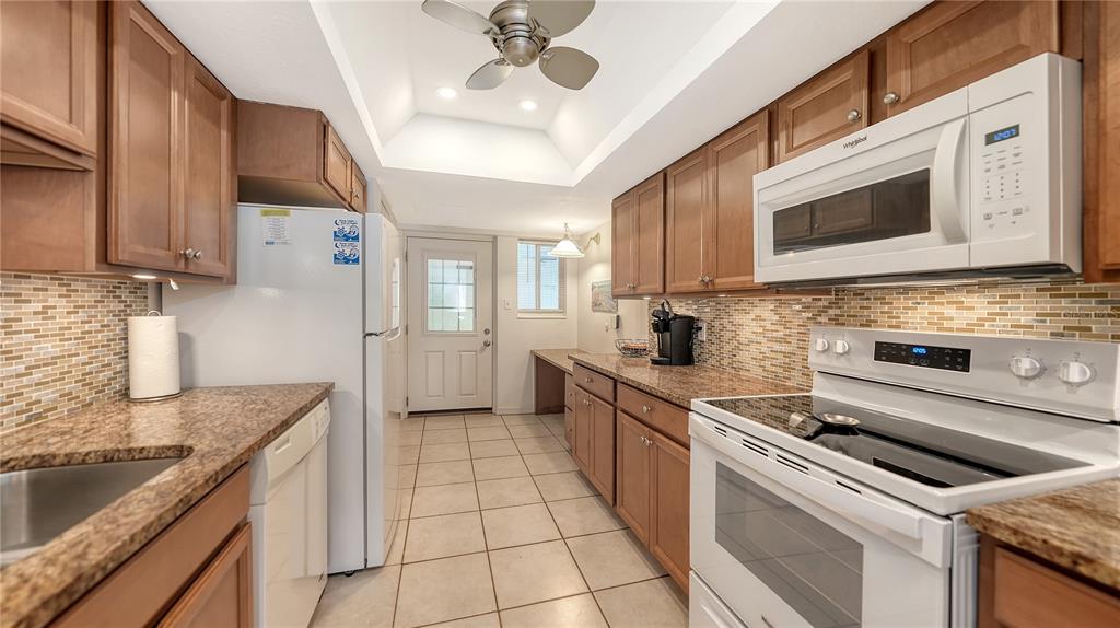 6144 Midnight Pass Road, Unit 2N Sarasota, FL 34242 - Photo 21 of 53 a kitchen with stainless steel appliances granite countertop a sink and cabinets