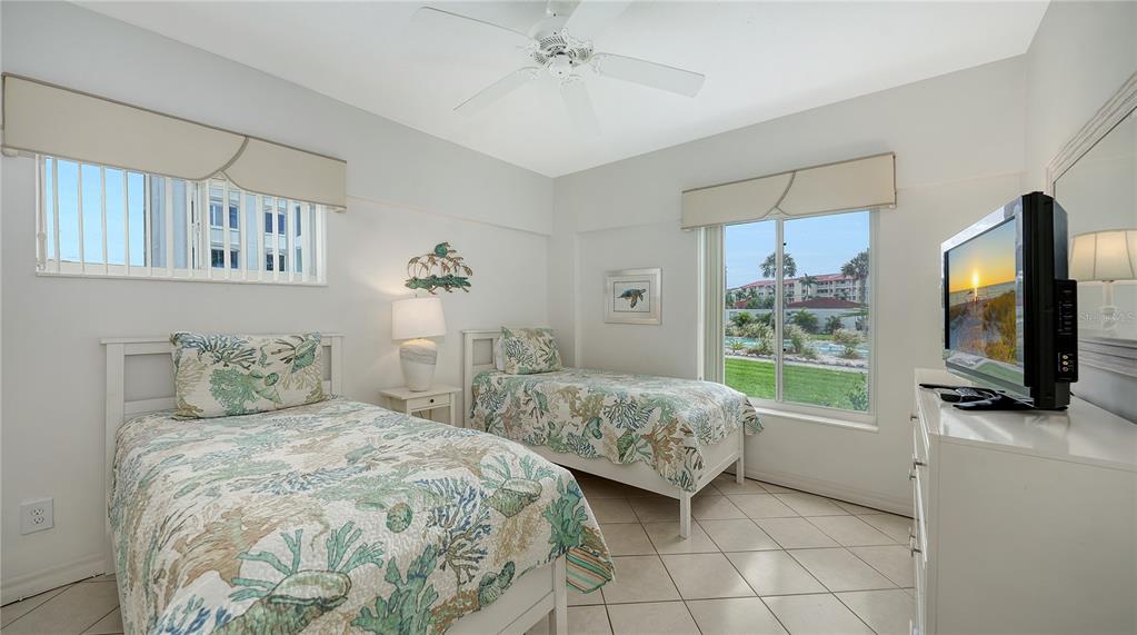 6144 Midnight Pass Road, Unit 2N Sarasota, FL 34242 - Photo 22 of 53 a bedroom with two beds and a flat screen tv