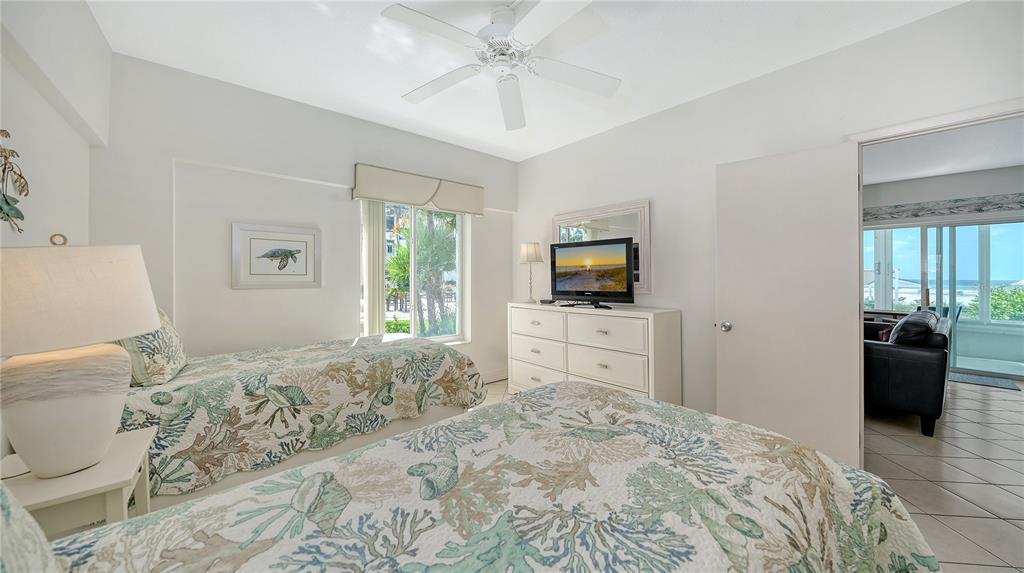 6144 Midnight Pass Road, Unit 2N Sarasota, FL 34242 - Photo 25 of 53 a bedroom with a bed and a flat screen tv in it