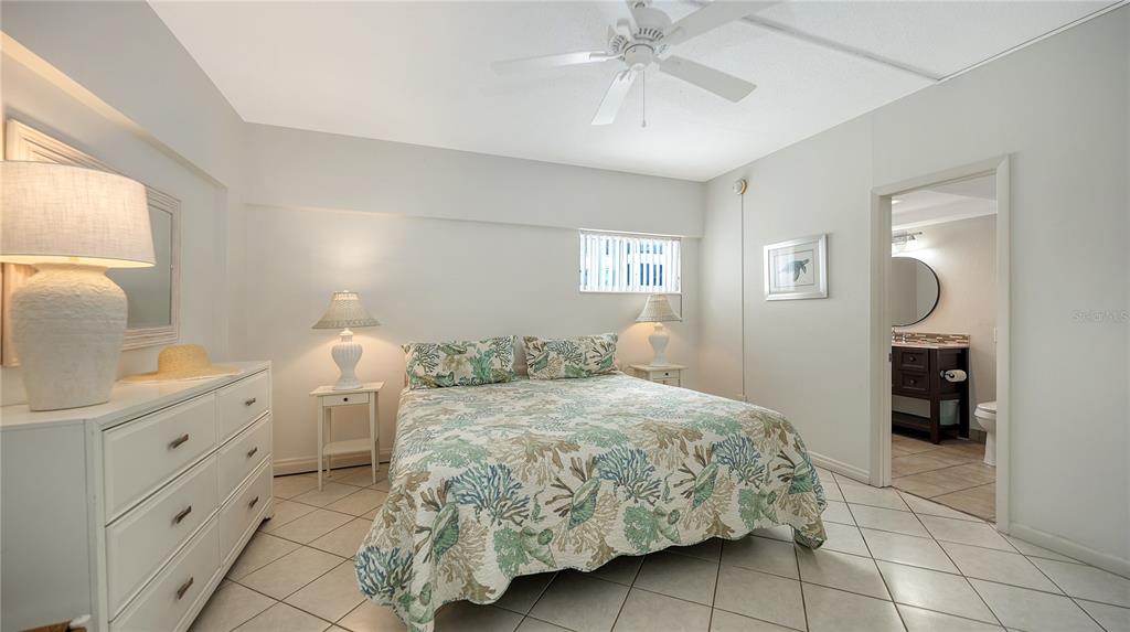 6144 Midnight Pass Road, Unit 2N Sarasota, FL 34242 - Photo 28 of 53 a bedroom with a bed and a chandelier