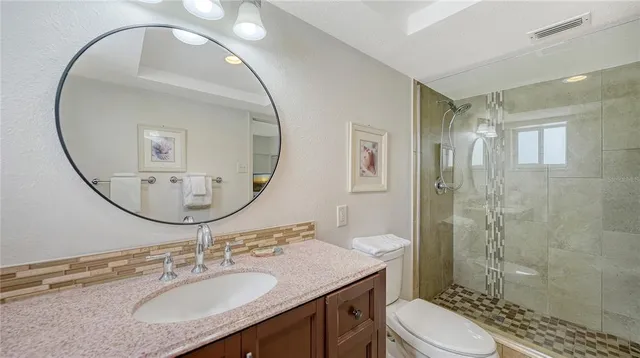 a bathroom with a sink a toilet and shower