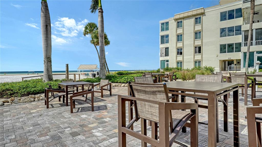 6144 Midnight Pass Road, Unit 2N Sarasota, FL 34242 - Photo 37 of 53 a view of a patio with table and chairs and potted plants
