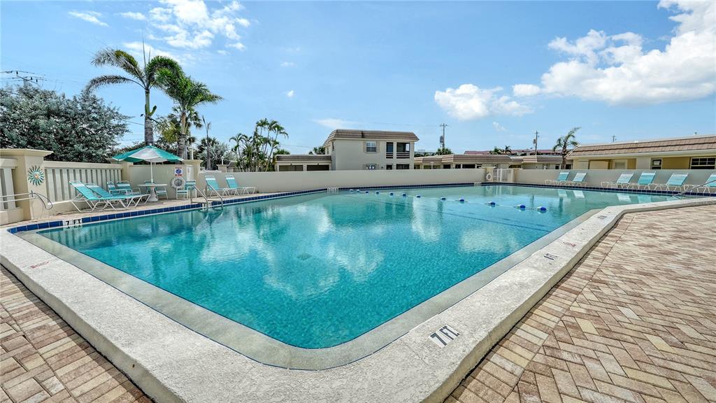 6144 Midnight Pass Road, Unit 2N Sarasota, FL 34242 - Photo 47 of 53 a view of a swimming pool with a patio and outdoor seating
