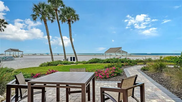 a view of a patio with furniture and a garden