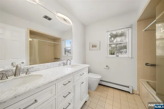 a spacious bathroom with a granite countertop sink a mirror and a bathtub