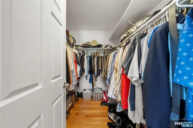 a view of walk in closet with clothes and shoes
