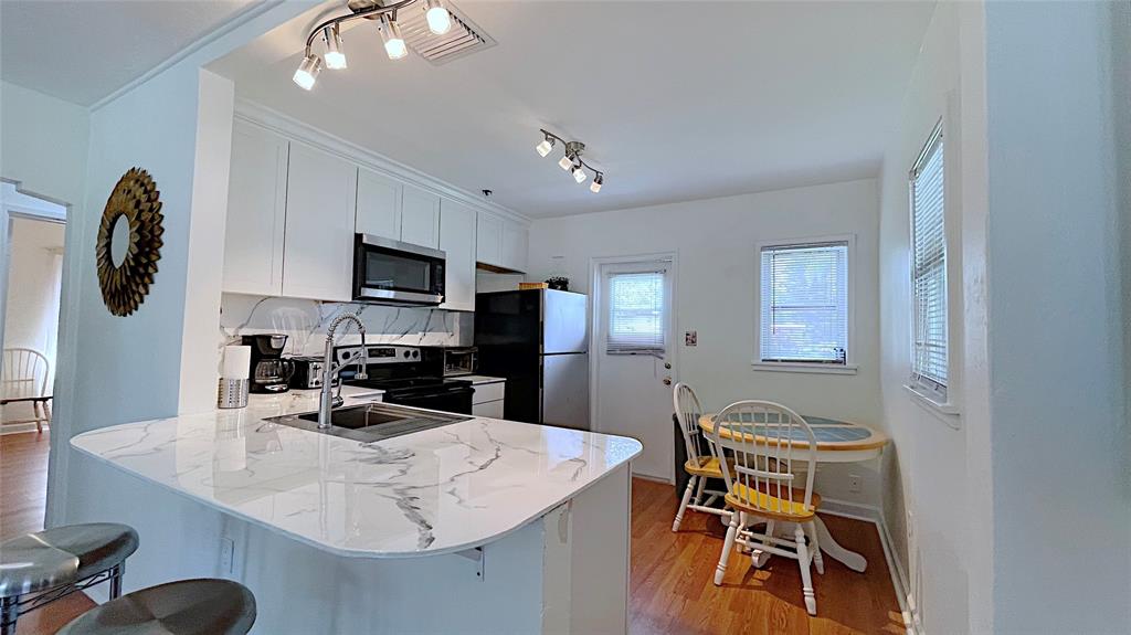 342 Southwest 2nd Avenue Dania Beach, FL 33004 - Photo 15 of 27 a kitchen with a table chairs a sink dishwasher stove and cabinets