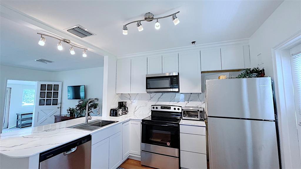 342 Southwest 2nd Avenue Dania Beach, FL 33004 - Photo 17 of 27 a white kitchen with sink refrigerator and microwave