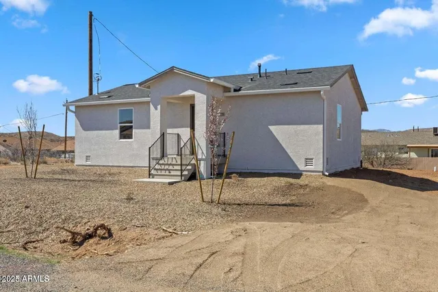 a view of a house with a wooden fence