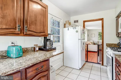a kitchen with stainless steel appliances granite countertop a refrigerator a stove and a sink
