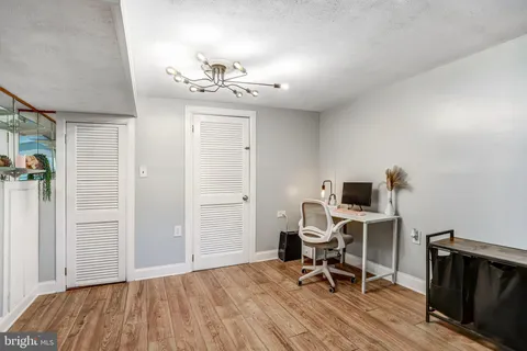 a view of a workspace with furniture and wooden floor