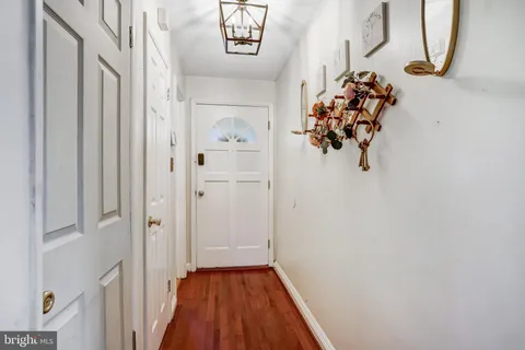 a view of a hallway with wooden floor and a chandelier