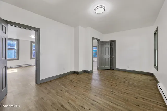 an empty room with wooden floor and closet