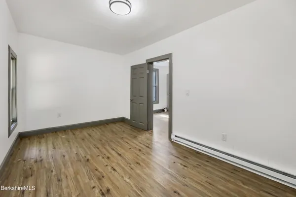 an empty room with wooden floor and closet