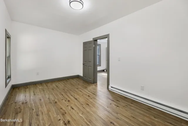an empty room with wooden floor and closet