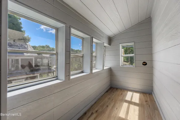 an empty room with wooden floor and closet area