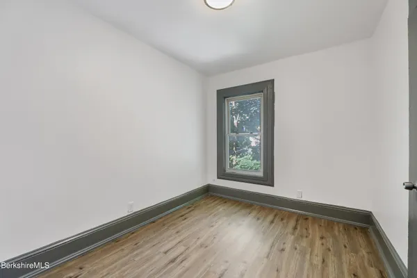 an empty room with wooden floor and closet