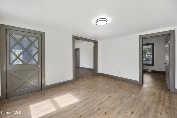 an empty room with wooden floor and a window