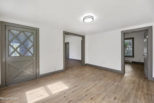 an empty room with wooden floor and a window