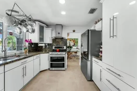 a kitchen with stainless steel appliances a sink cabinets and refrigerator