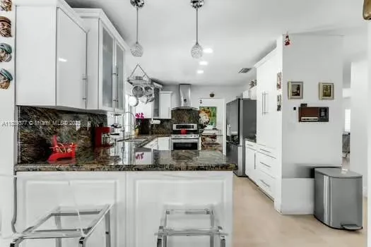 a kitchen with stainless steel appliances granite countertop a refrigerator and microwave
