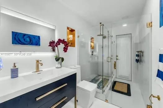 a bathroom with a sink a toilet and shower