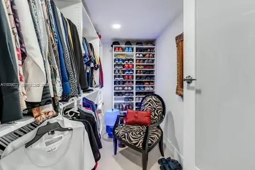 a view of walk in closet with clothes and shoes