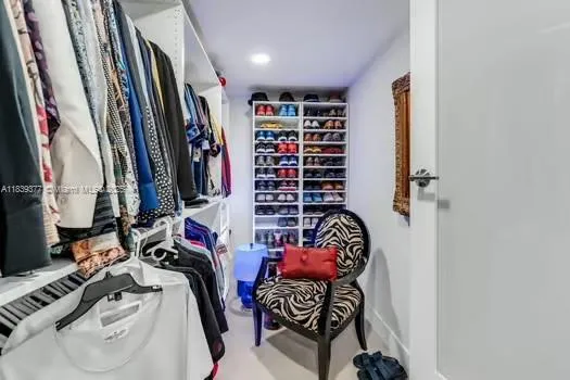 a view of walk in closet with clothes and shoes