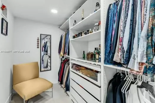 a view of walk in closet with clothes and shoes
