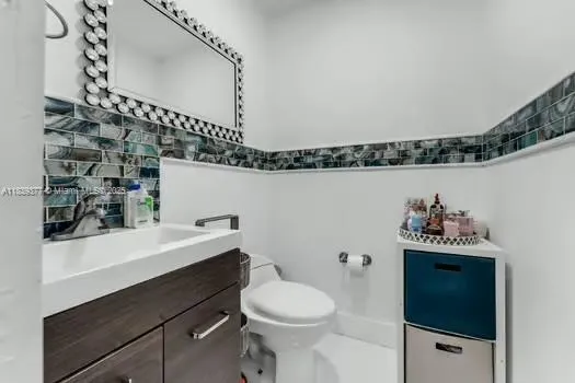 a bathroom with a sink a toilet and a mirror