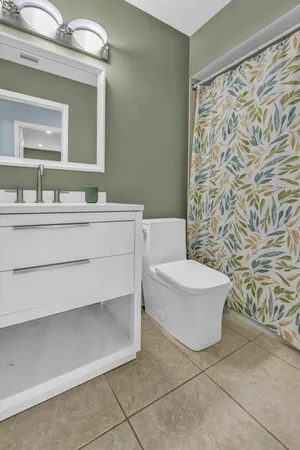 a bathroom with a sink a toilet and a mirror