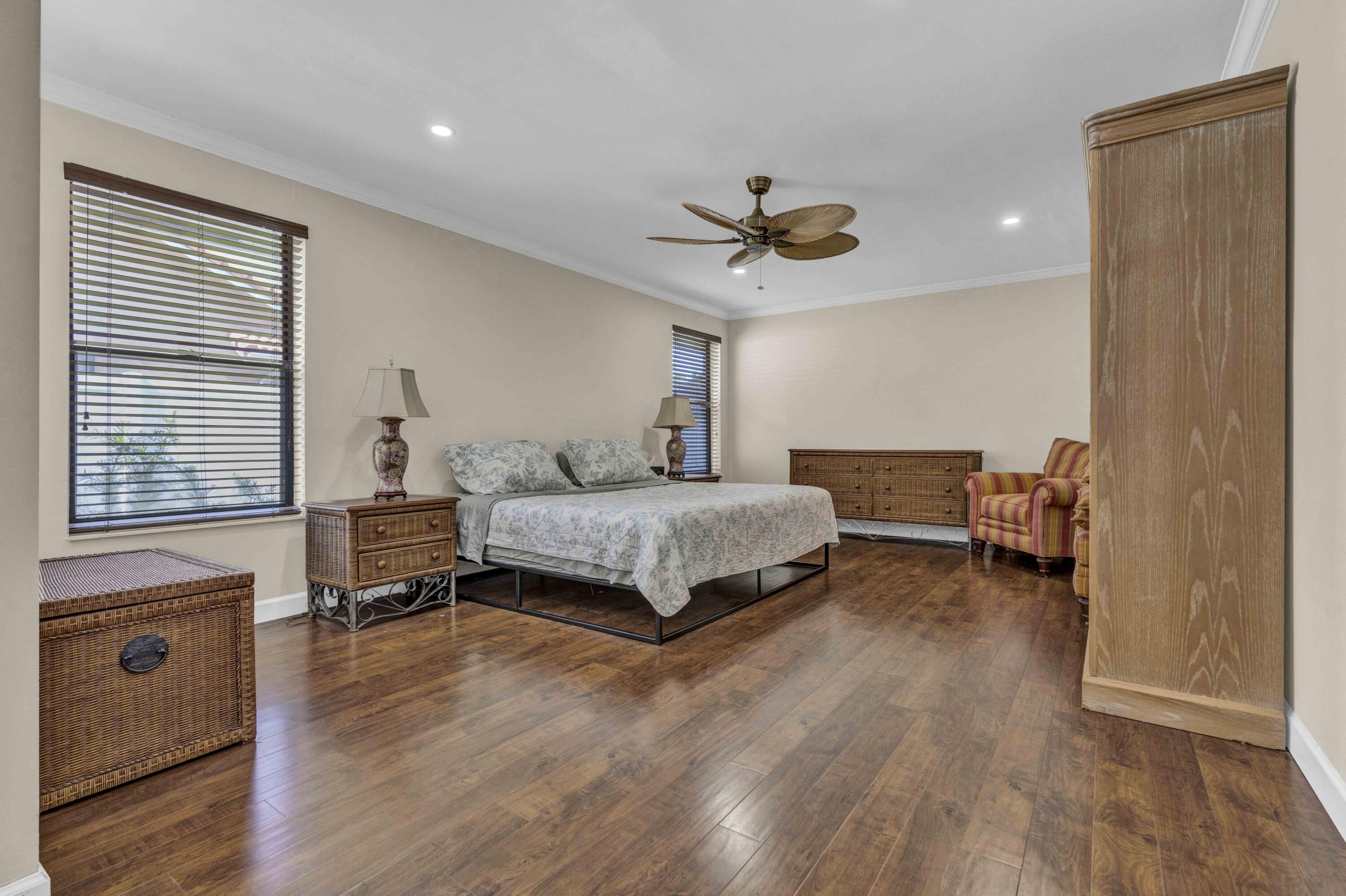 22323 Martella Avenue Boca Raton, FL 33433 - Photo 6 of 21 a bedroom with a bed a dresser and wooden floor