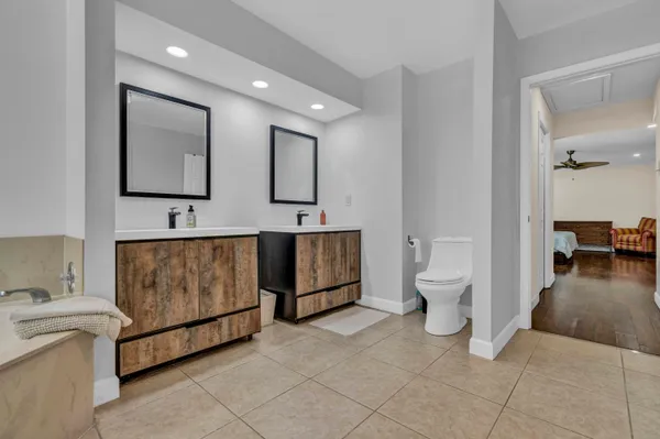 a spacious bathroom with a toilet sink and mirror