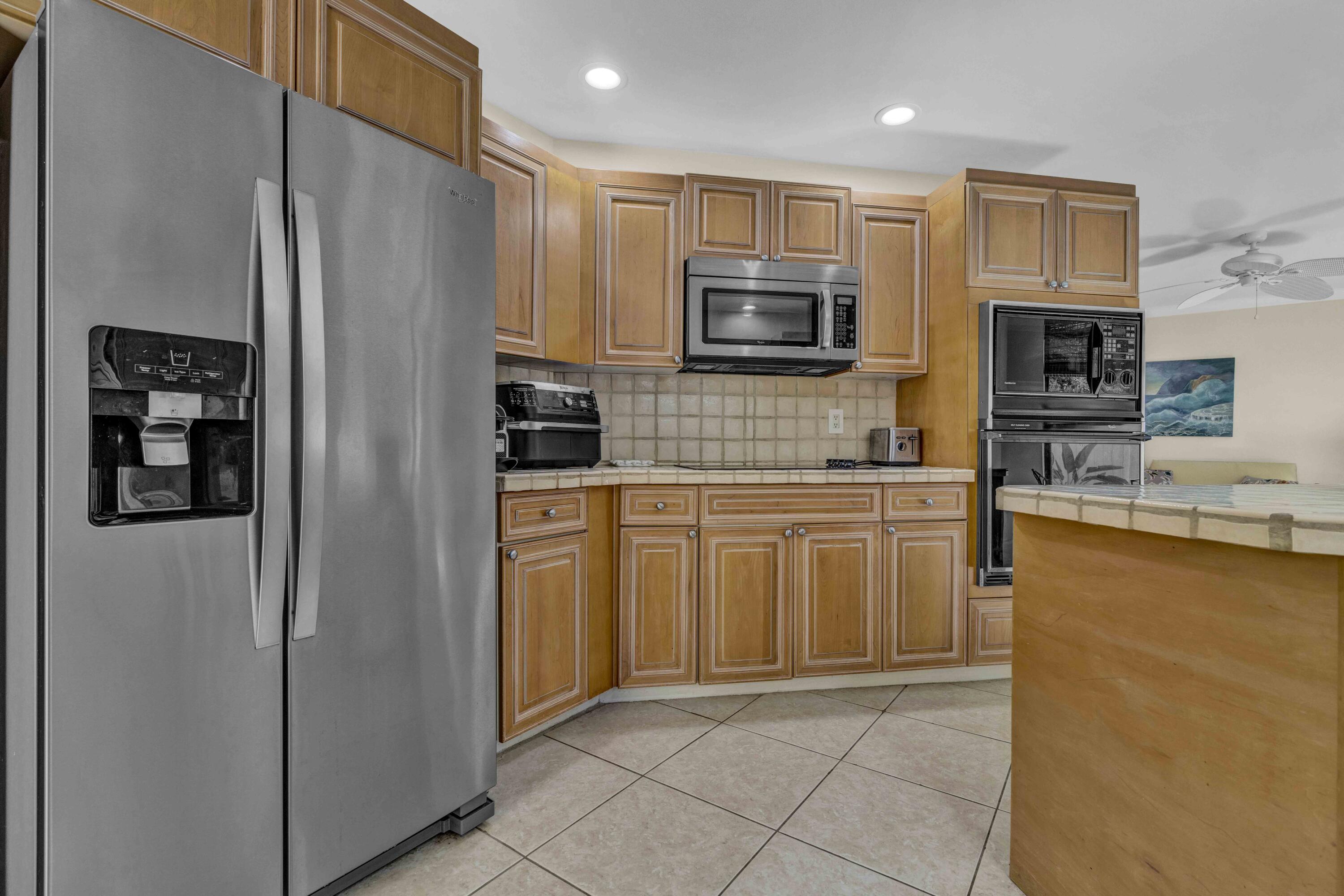 22323 Martella Avenue Boca Raton, FL 33433 - Photo 9 of 21 a kitchen with stainless steel appliances a refrigerator stove microwave and sink