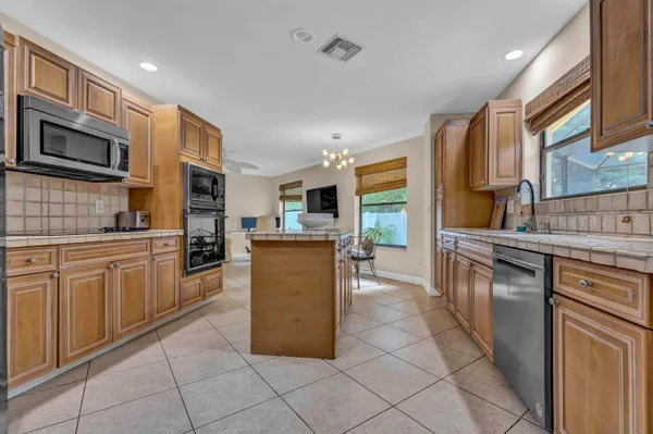 a kitchen with stainless steel appliances granite countertop a stove top oven a sink dishwasher and a refrigerator