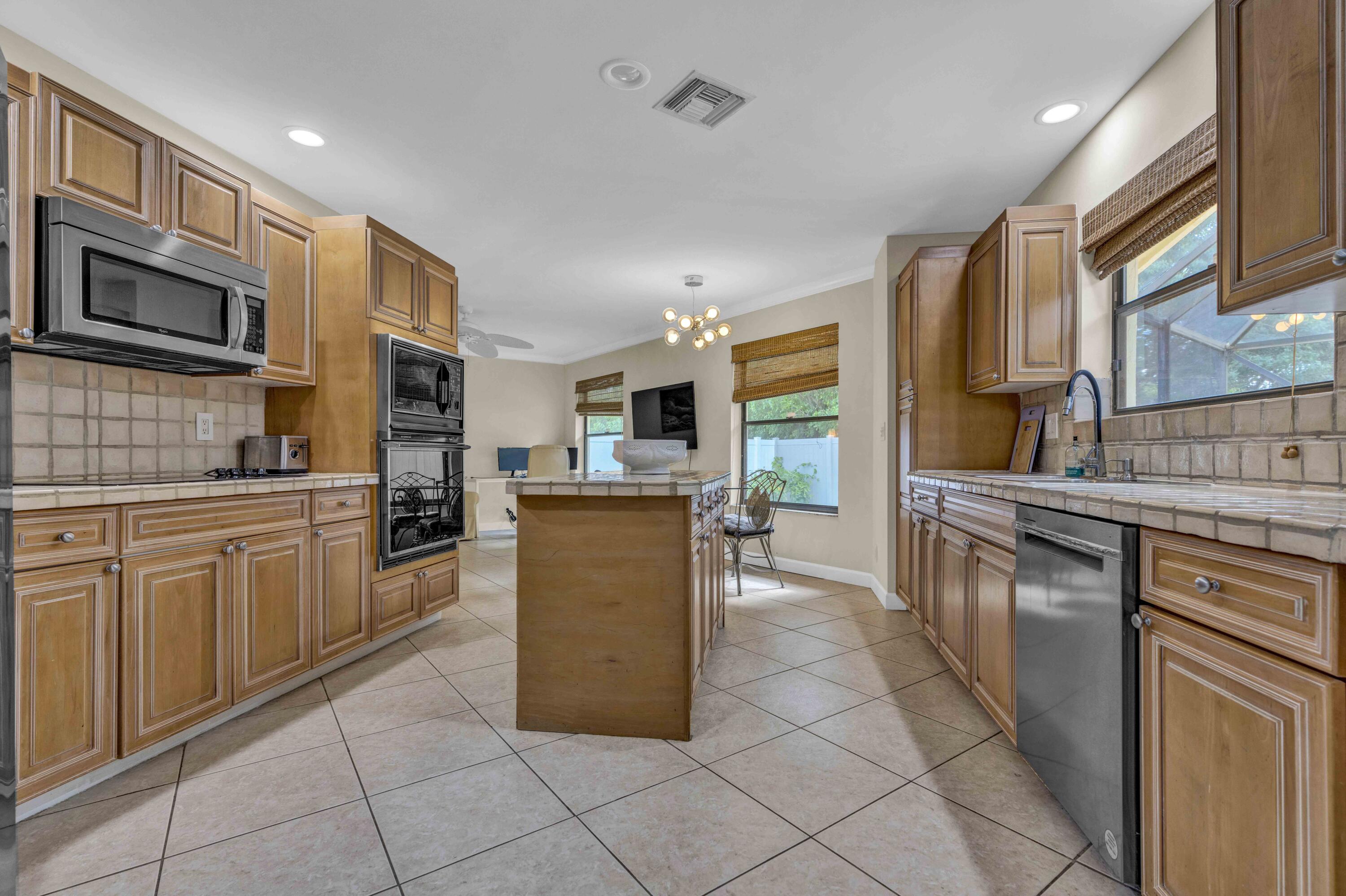 22323 Martella Avenue Boca Raton, FL 33433 - Photo 10 of 21 a kitchen with stainless steel appliances granite countertop a stove top oven a sink dishwasher and a refrigerator