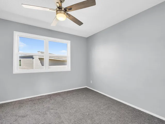 a view of an empty room with window and cabinet