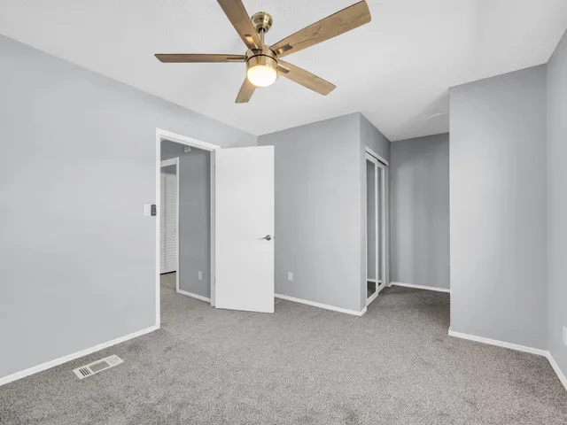 an empty room with closet and fan