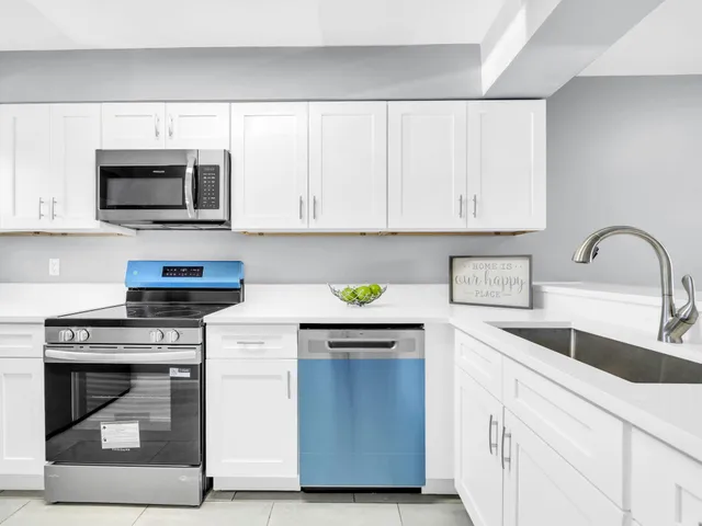 a kitchen with stainless steel appliances granite countertop a stove a microwave and a sink