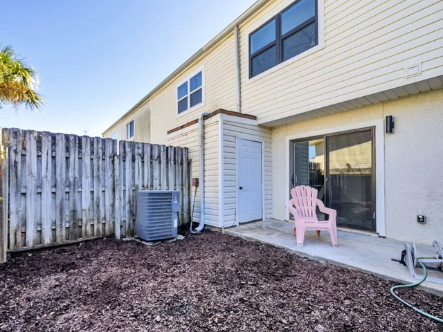 a backyard of a house with barbeque oven table and chairs