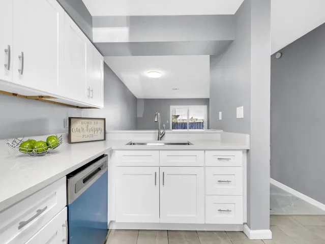 a kitchen with white cabinets and appliances
